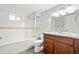 Bathroom featuring soaking tub with glass doors, granite countertop vanity, and white tile at 335 N 11Th Ave, Brighton, CO 80601