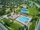 Aerial view of community pool, tennis courts, and clubhouse surrounded by lush green trees and neighborhood at 16177 E Prentice Pl, Centennial, CO 80015