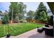 A spacious backyard with lush green grass, a deck, privacy fence, and mature trees at 16177 E Prentice Pl, Centennial, CO 80015