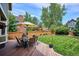 Enjoy the beautifully landscaped backyard with dining furniture and green lawn at 16177 E Prentice Pl, Centennial, CO 80015