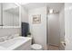 Well-lit bathroom features a vanity sink, toilet, shower and decorative artwork at 16177 E Prentice Pl, Centennial, CO 80015