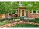 Charming brick home features a welcoming front porch with chairs and beautifully landscaped front yard at 16177 E Prentice Pl, Centennial, CO 80015