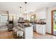 Bright kitchen with stainless steel appliances, granite countertops, island with seating, and white cabinets at 16177 E Prentice Pl, Centennial, CO 80015