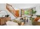 Bright living room with staircase, wooden door, large windows, and comfortable furnishings at 16177 E Prentice Pl, Centennial, CO 80015