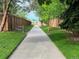 Cement walkway lined by green grass and bordered by a wooden fence on both sides at 16177 E Prentice Pl, Centennial, CO 80015