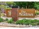 Welcome sign for 'The Meadows' featuring a decorative brick pillar and lush green landscaping at 16177 E Prentice Pl, Centennial, CO 80015