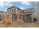 Two-story home featuring a brown exterior, brick accents, manicured lawn, mature trees and blue sky at 6373 E 130Th Ave, Thornton, CO 80602