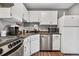 White cabinets, stainless steel appliances, and dark countertops in this galley kitchen at 63 S Sable Blvd # 16, Aurora, CO 80012