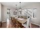 Dining area featuring a large wooden table under decorative chandeliers, with an open layout and hardwood floors at 14258 Greenfield Loop, Parker, CO 80134