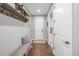 Inviting entryway with bench seating, dark wood floors, open shelving, and a view to an adjacent room at 14258 Greenfield Loop, Parker, CO 80134