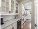 Open butler's pantry featuring white cabinets, glass displays, and granite countertop, adding sophistication to the kitchen at 14258 Greenfield Loop, Parker, CO 80134
