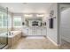 Well-lit main bathroom featuring dual sinks, a soaking tub, and a separate glass-enclosed shower at 14258 Greenfield Loop, Parker, CO 80134