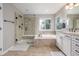 Well-lit bathroom featuring dual sinks, soaking tub, and separate glass-enclosed shower at 14258 Greenfield Loop, Parker, CO 80134