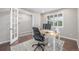 Bright home office with a light colored desk and shuttered window next to glass paneled doors at 14258 Greenfield Loop, Parker, CO 80134