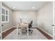 A home office space with a neutral palette featuring a bright window and light colored desk on a patterned rug at 14258 Greenfield Loop, Parker, CO 80134