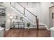 Open staircase with dark wood floors and white railings next to a console table with decorative items at 14258 Greenfield Loop, Parker, CO 80134