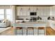 Modern kitchen boasts white cabinets, quartz countertops, and a large island with seating at 4237 Ridgewalk Pt, Castle Rock, CO 80108