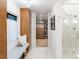 Sleek bathroom with marble floors, glass shower, and built-in wooden cabinets leading to the walk-in closet at 4590 Wolff St, Denver, CO 80212