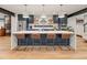 Modern kitchen boasts a spacious center island with seating, designer lighting and a suite of stainless steel appliances at 4590 Wolff St, Denver, CO 80212