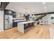 Bright open kitchen with stainless steel appliances, center island with breakfast bar seating and hardwood floors at 4590 Wolff St, Denver, CO 80212