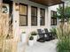 Inviting porch with chairs, plants, white brick and black trim exudes cozy curb appeal and architectural details at 4590 Wolff St, Denver, CO 80212