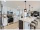 Modern kitchen with white cabinets, stainless steel appliances, and a large island with seating at 3082 S Florence Ct, Denver, CO 80231