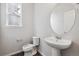 Powder room with pedestal sink, oval mirror, and modern fixtures at 1341 Loraine N Cir, Lafayette, CO 80026