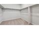 Walk-in closet featuring ample rod space and neutral carpeting at 1341 Loraine N Cir, Lafayette, CO 80026