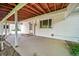 Covered porch with exposed beam ceiling, concrete floor and white painted siding and supports at 2571 S Birch St, Denver, CO 80222