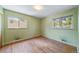 Bright bedroom featuring hardwood floors, two windows letting in natural light, and neutral-toned walls at 2571 S Birch St, Denver, CO 80222