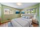 Cozy bedroom with hardwood floors, a large bed with blue pillows, and bright natural light from two windows at 2571 S Birch St, Denver, CO 80222