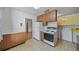 Spacious kitchen with wood cabinets, white appliances, and access to additional rooms at 2571 S Birch St, Denver, CO 80222