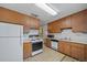 Well-lit kitchen with wood cabinets, white appliances, and a practical layout at 2571 S Birch St, Denver, CO 80222