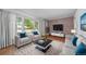 Bright living room featuring hardwood floors, a large window, and modern furnishings with a brick accent wall at 2571 S Birch St, Denver, CO 80222