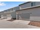 Attached garages with light gray doors and siding, showing ample parking and modern design at 1443 Great Western Dr, Longmont, CO 80501