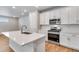 Modern kitchen features white cabinets, stainless appliances, quartz countertops, and chevron backsplash at 1443 Great Western Dr, Longmont, CO 80501