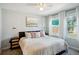 Bright bedroom with a cozy bed, an art piece, and light streaming through large windows with white curtains at 4080 Adams St, Denver, CO 80216