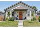 Charming home with a welcoming orange front door and a well-manicured lawn at 4080 Adams St, Denver, CO 80216