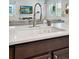 Close up of the kitchen with a white countertop, a stainless steel faucet, and a view of the living room beyond at 4080 Adams St, Denver, CO 80216