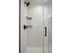 Close-up of the walk-in shower featuring white subway tile, black fixtures, and a glass door at 4080 Adams St, Denver, CO 80216