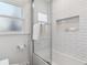 Shower with subway tile and glass door, featuring built-in shelving and sleek fixtures at 474 S Gaylord St, Denver, CO 80209