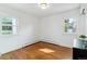 Minimalist bedroom featuring hardwood floors, bright white walls, and plenty of natural light from two windows at 474 S Gaylord St, Denver, CO 80209