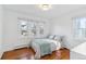 Bright bedroom with hardwood floors, large windows, and a cozy queen bed with blue coverlet at 474 S Gaylord St, Denver, CO 80209