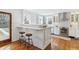 Bright open-concept kitchen with a bar, stainless steel appliances, and stylish pendant lighting at 474 S Gaylord St, Denver, CO 80209