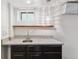 Basement wet bar featuring granite counters, a sink, wood shelf and a decorative pendant light at 474 S Gaylord St, Denver, CO 80209