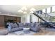 Open-concept living room with modern chandelier, sleek staircase, and gray sectional sofa at 1016 24Th St, Golden, CO 80401