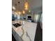Modern kitchen featuring a large island with quartz countertops, pendant lighting, and open to the living area at 8163 S Valleyhead Way, Aurora, CO 80016
