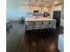 Bright kitchen with an expansive island, bar seating, and white cabinetry, illuminated by pendant lighting at 8163 S Valleyhead Way, Aurora, CO 80016