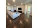 Bright living room with hardwood flooring, a stone fireplace, and an open layout leading to a bedroom at 8163 S Valleyhead Way, Aurora, CO 80016