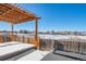 Covered patio with pergola, hot tub, and snowy landscape at 9485 Joyce Ln, Highlands Ranch, CO 80126